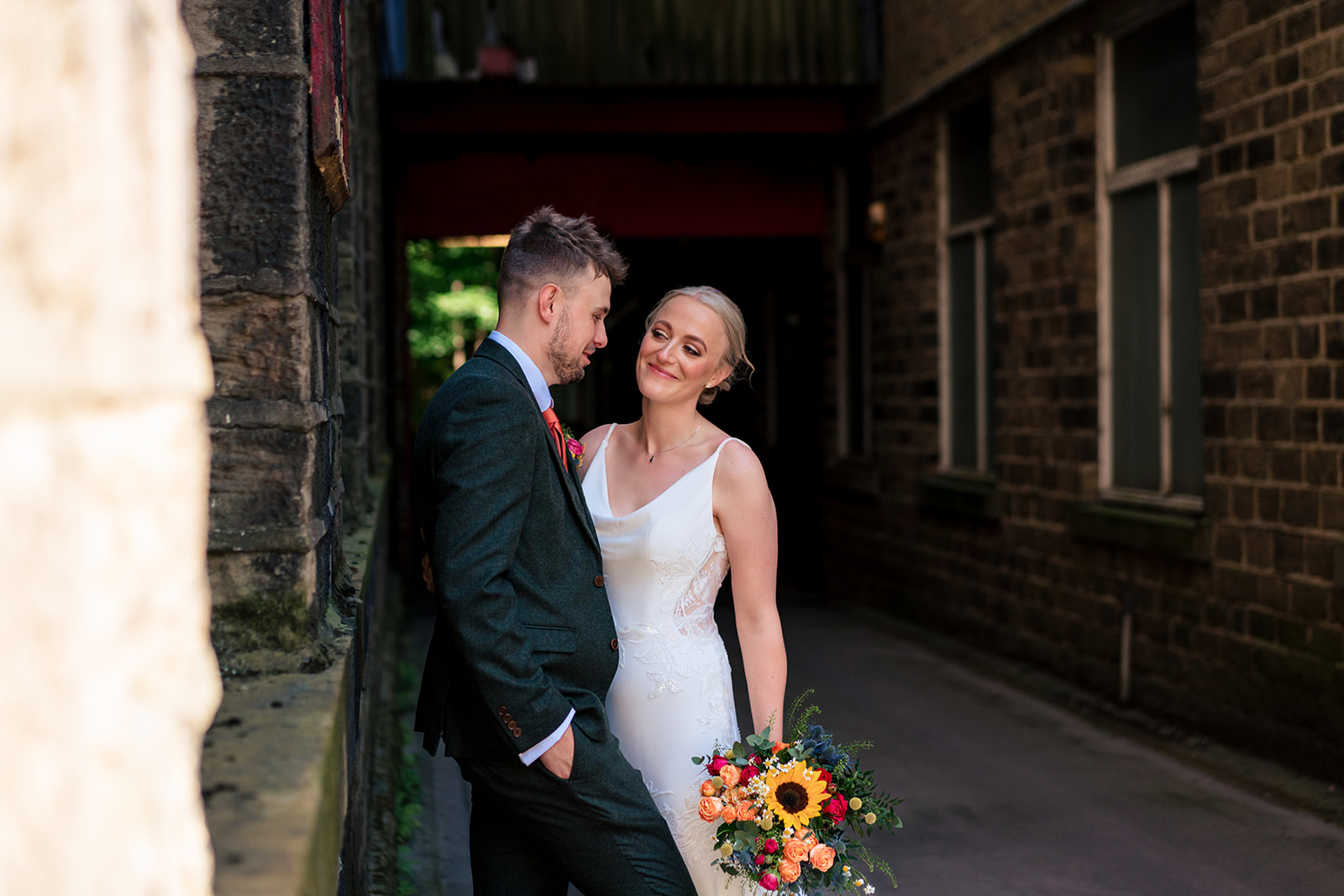 Hollie and Elliot together beside the brick mill buildings at Bowers Mill