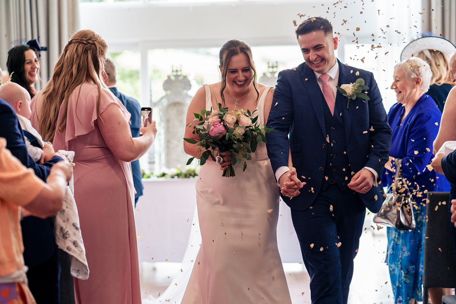 Chloe and Jordan walking through confetti after their ceremony