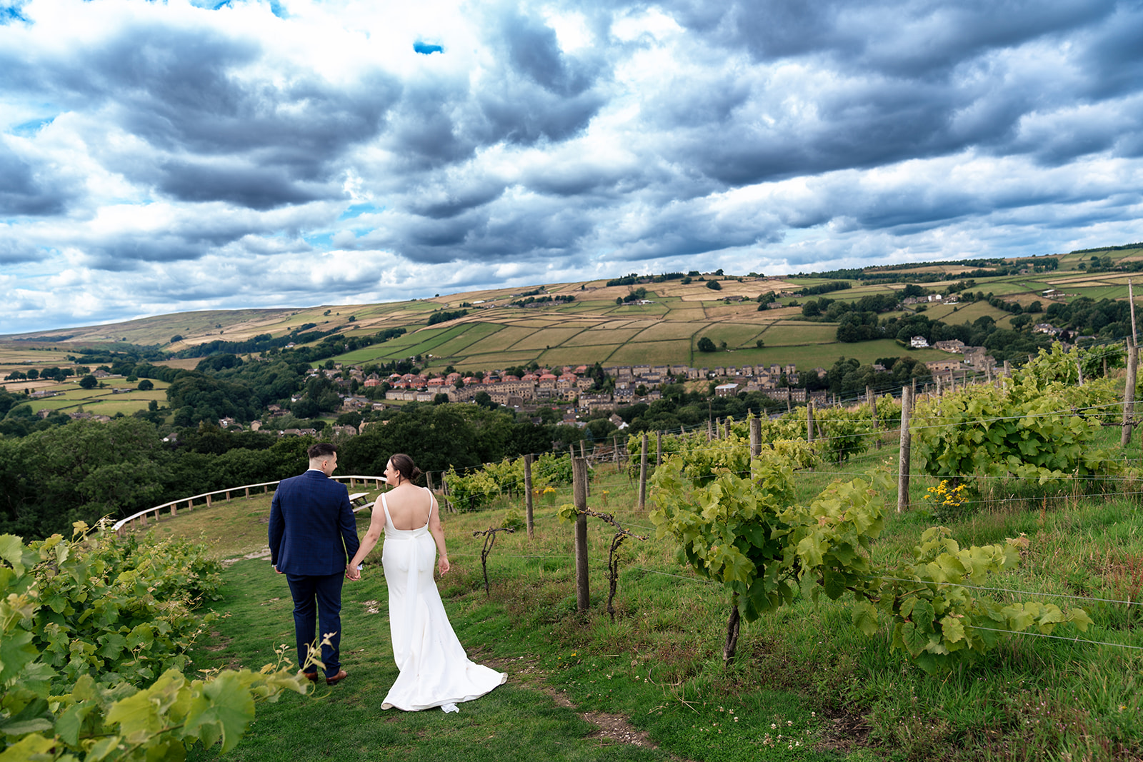 Chloe and Jordan walking together through the vineyard