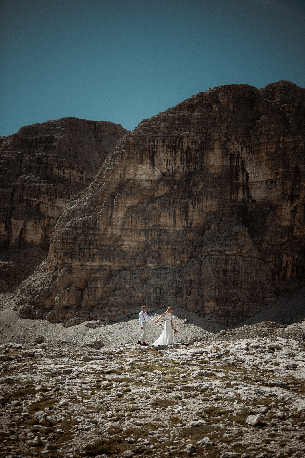 Matrimonio nelle Dolomiti – coppia che si tiene per mano circondata dalle montagne, momento intimo durante un matrimonio in Alto Adige