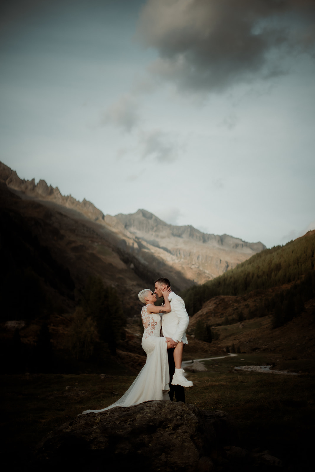 Elopement nelle Dolomiti – ritratto romantico e intenso di coppia alla luce del tramonto con le montagne sullo sfondo, nel cuore di una valle alpina