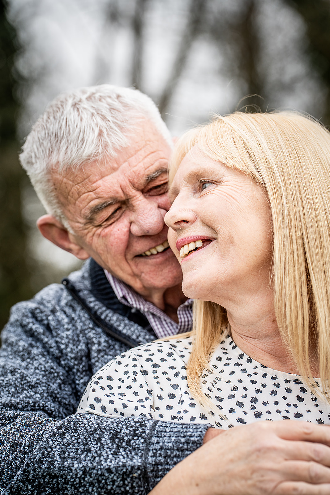 An older couple laughing cheek to cheek