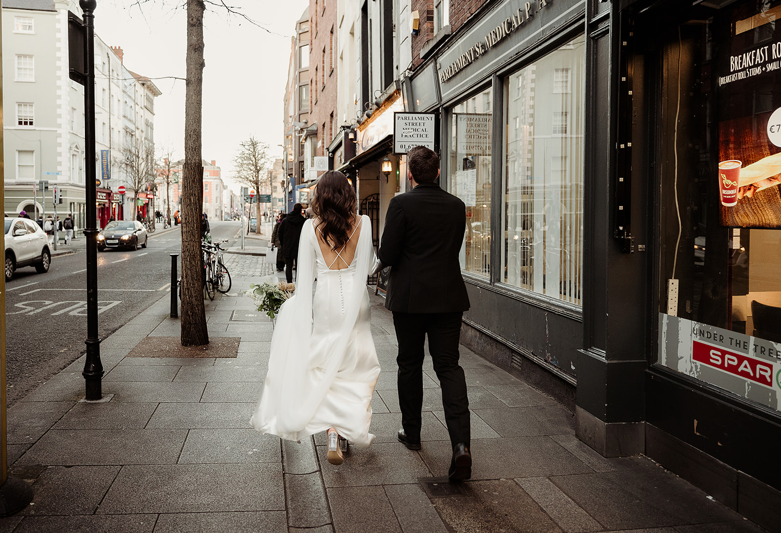 Sayeda and Aaron walking together through Dublin city centre on their wedding day