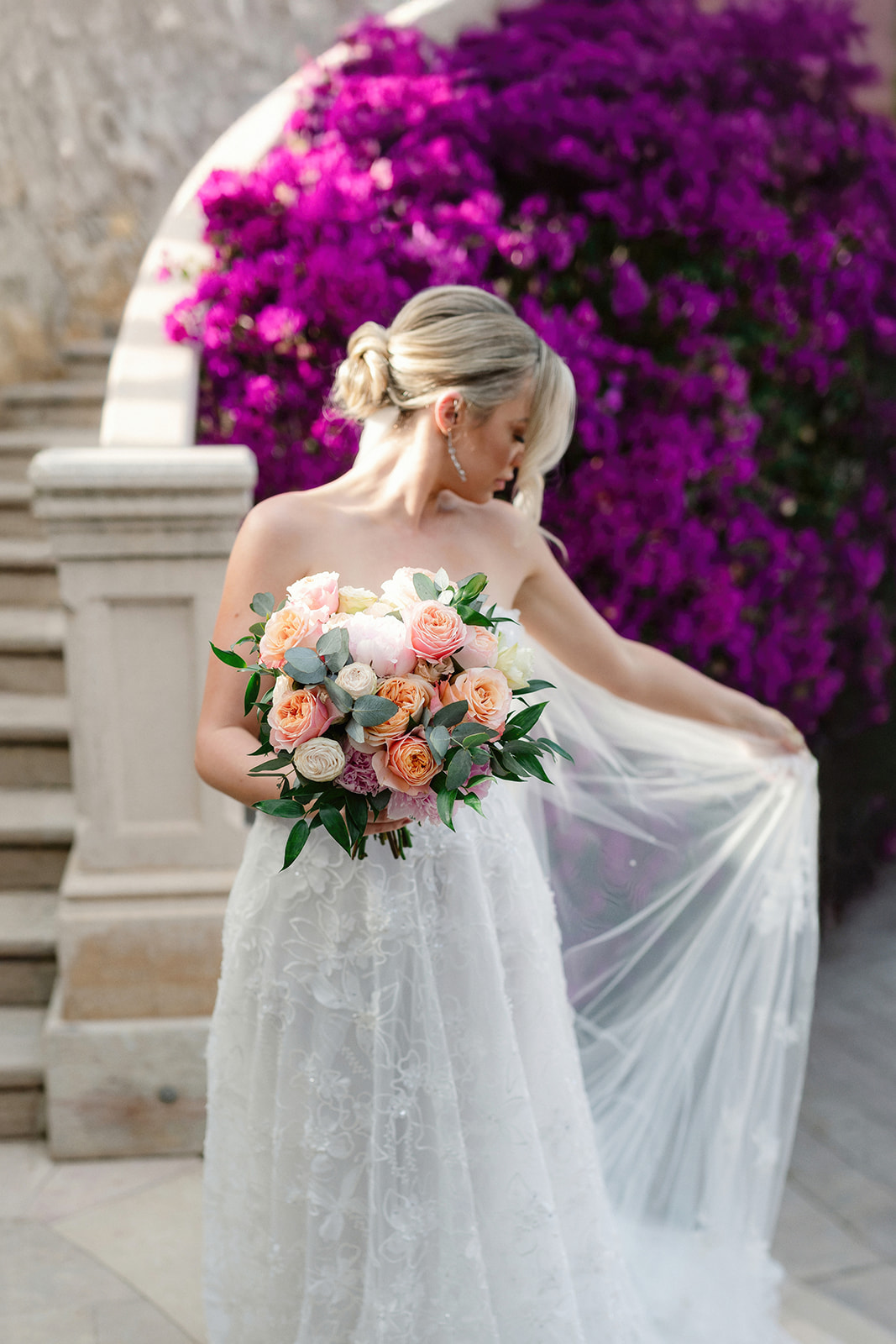 Bride with her bouquet beside bougainvillea at Xalet del Nin