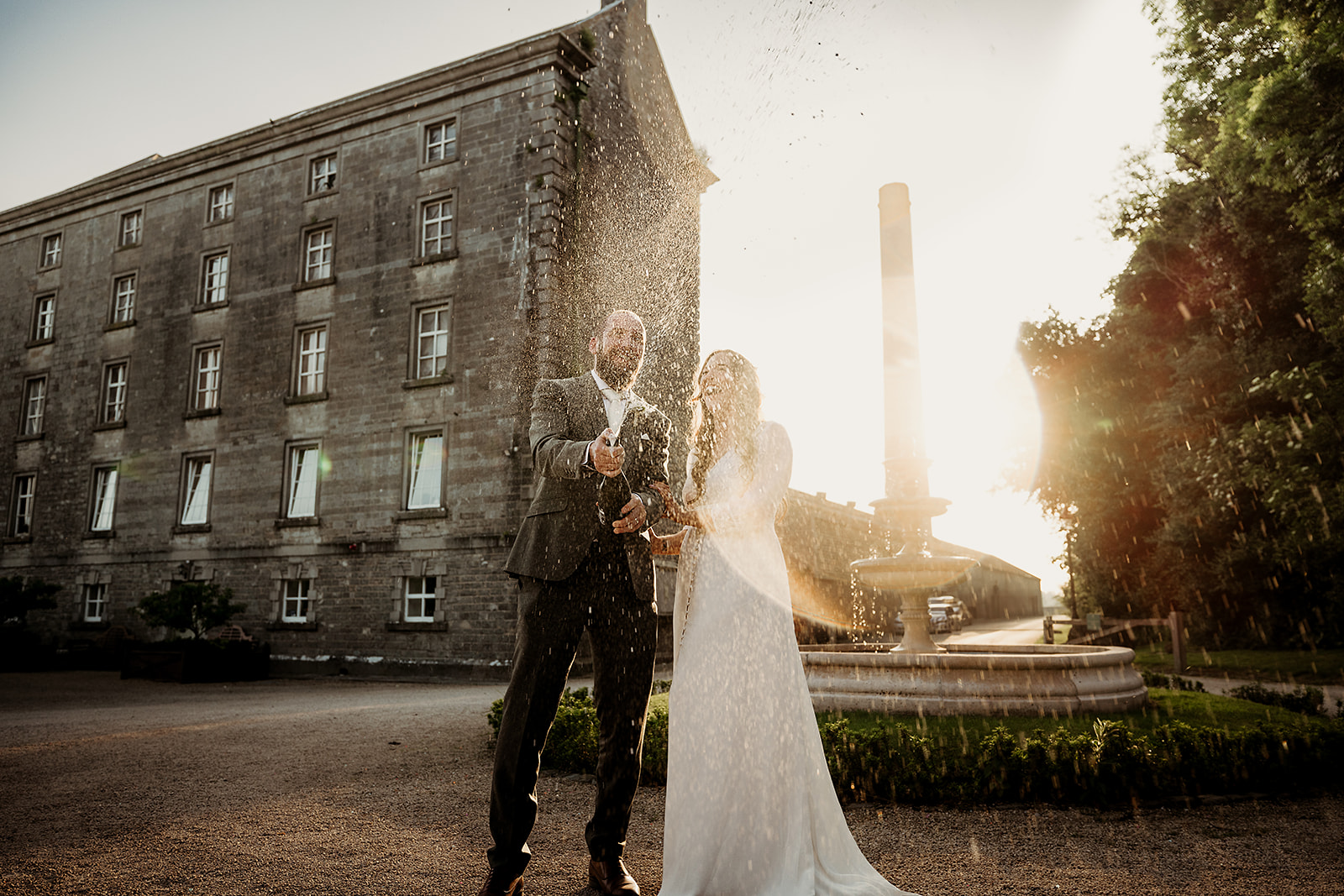 Sarah and Kieran celebrating in the evening light outside The Millhouse