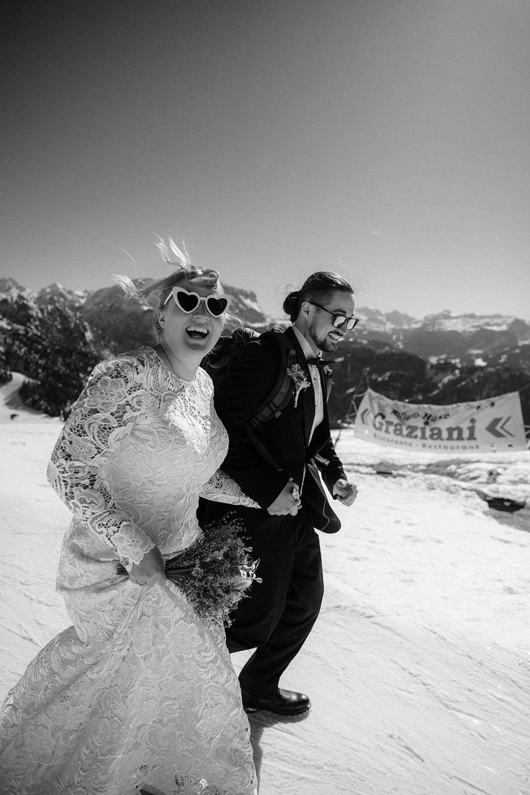 Dolomites Elopement Packages - Winter elopment fun on the slopes with wind in the couple's hair, smiling