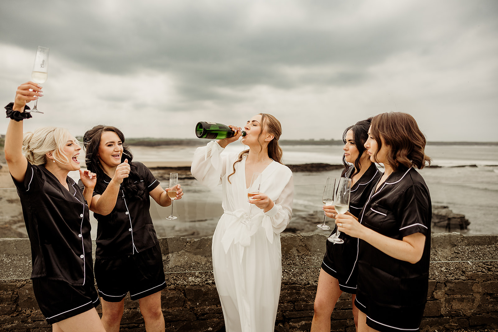 Alison celebrating with friends beside the sea before the ceremony