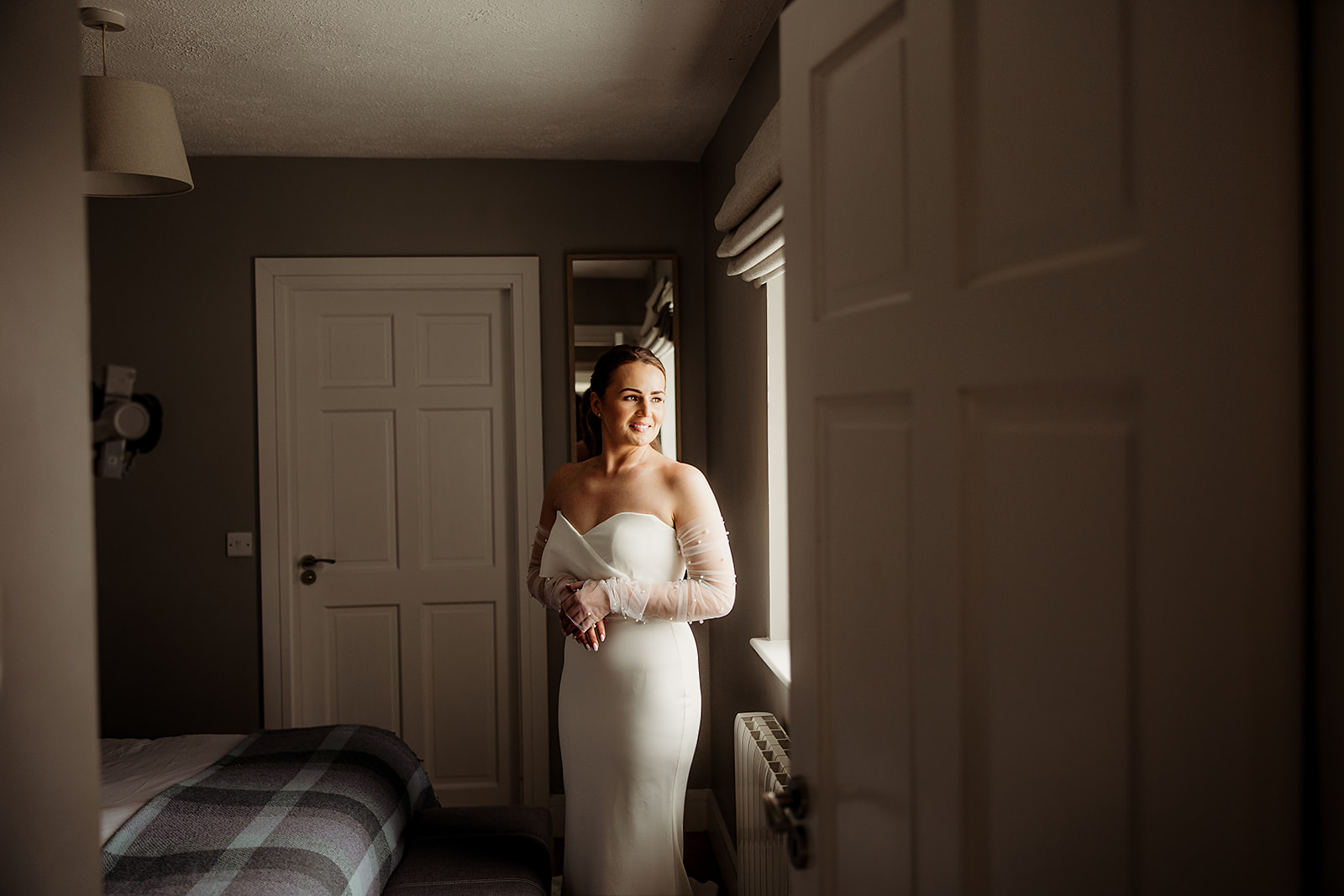 Alison standing in soft window light before the ceremony