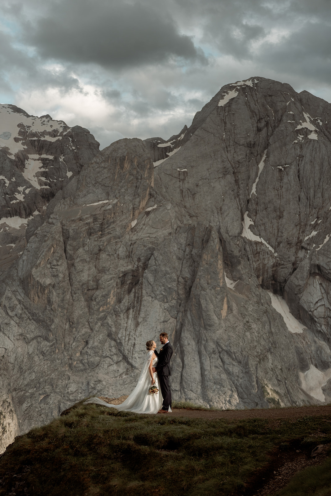 sposarsi in alto adige, coppia che si guarda negli occhi con enorme montagna dietro