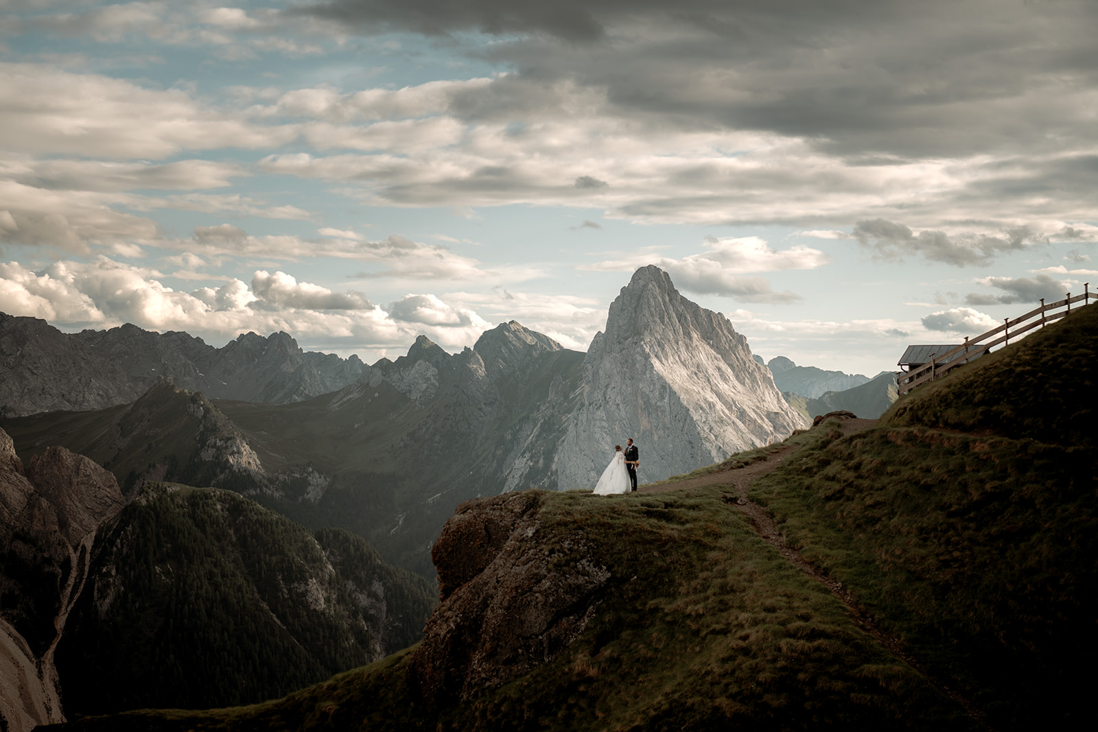 Sposarsi nelle Dolomiti – coppia che si abbraccia nella luce morbida della sera tra le montagne, con una grande cima sullo sfondo
