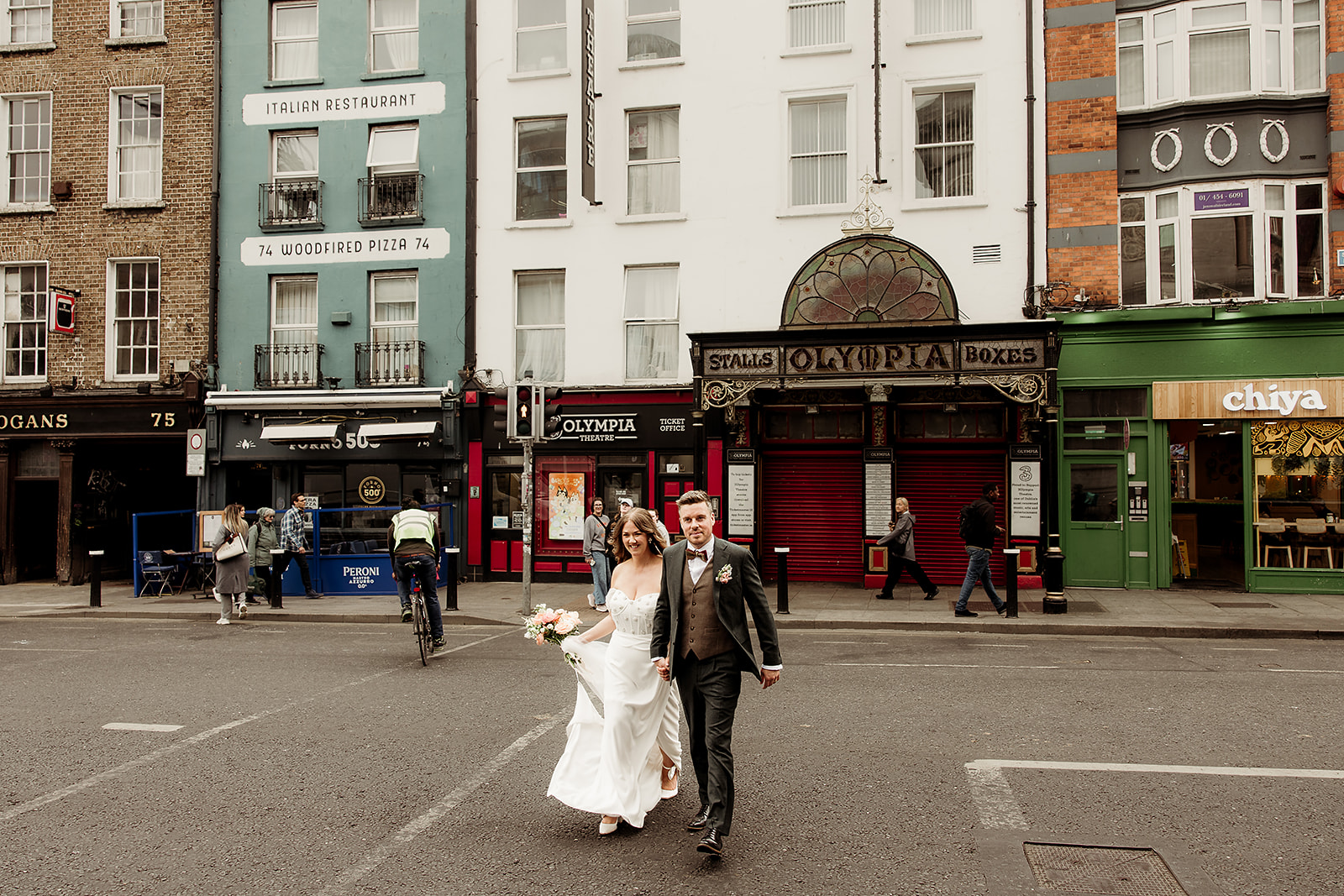 Claire and David crossing a Dublin street with colourful city buildings behind them