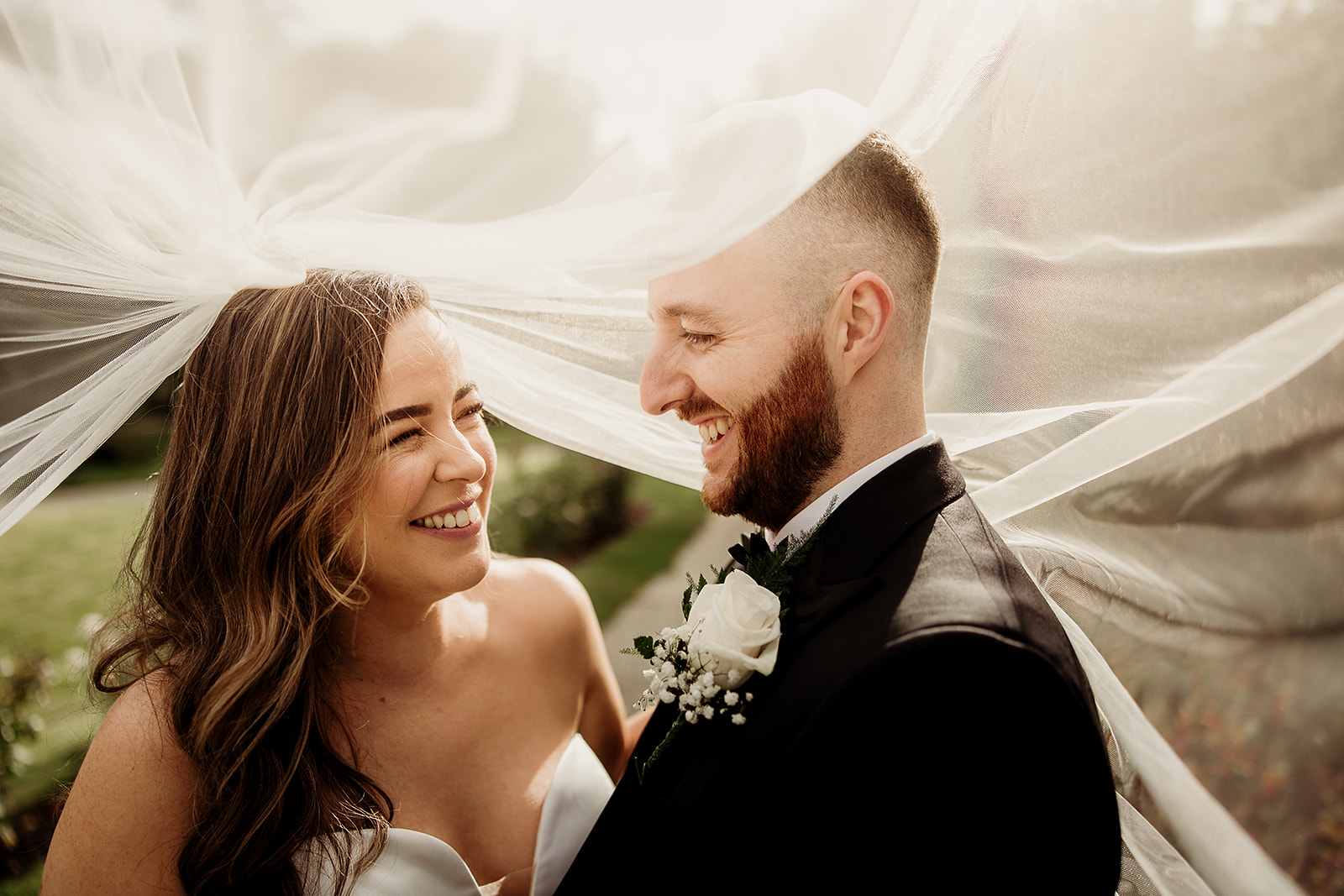 Linda and Michael laughing beneath her veil at Boyne Hill House.