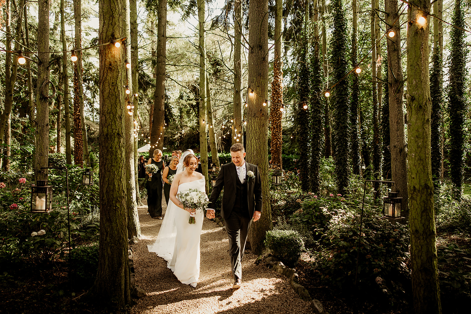 Nicola and Conor walking through the trees after their ceremony at the Station House Hotel