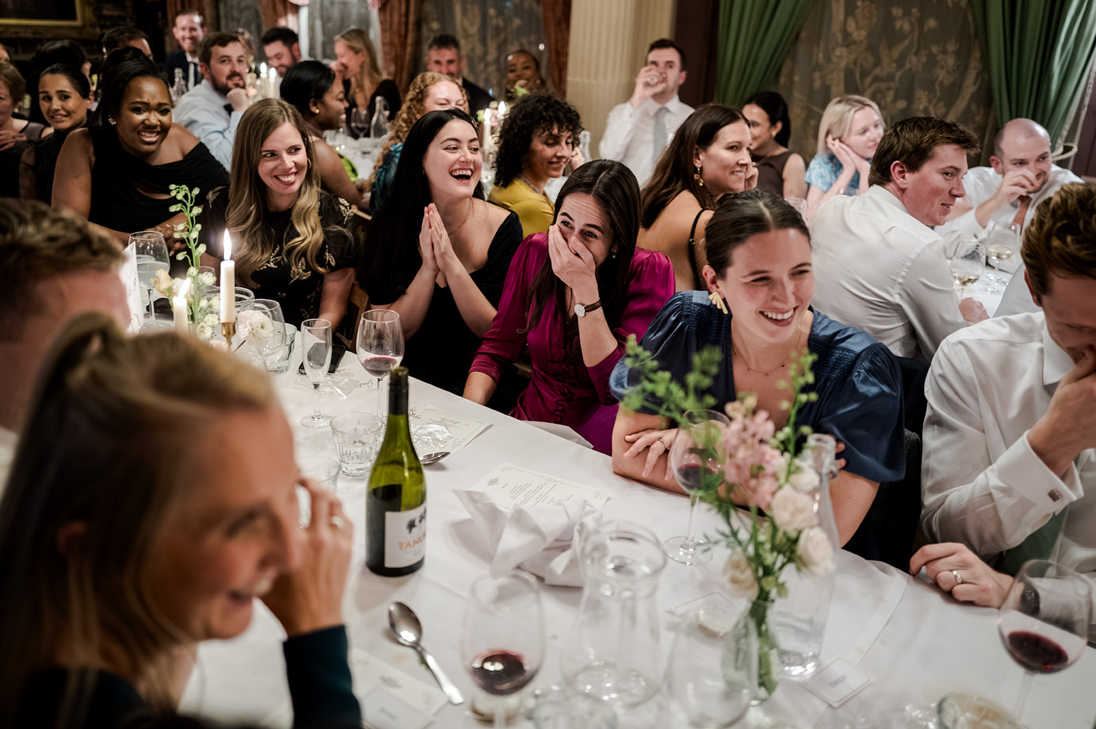 Candid moment during the speeches — laughter at the table