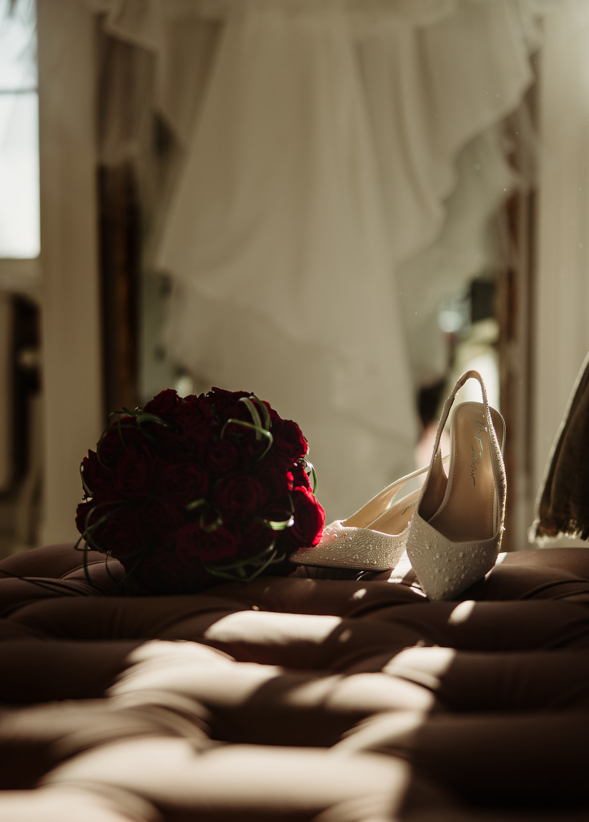 Jolene’s wedding shoes and burgundy bouquet in window light