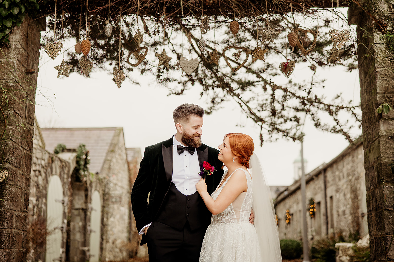 Caoimhe and James beneath the decorated courtyard arch at Ballymagarvey Village