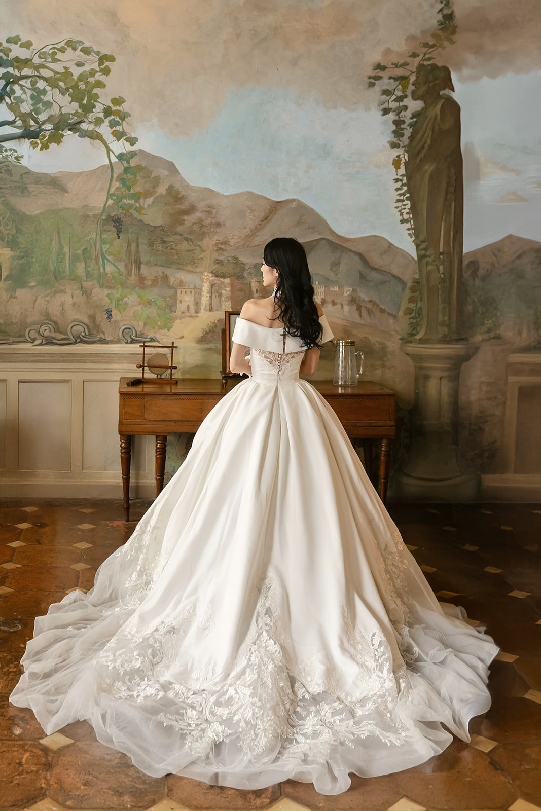 Bride in a ball gown in a frescoed room of a Tuscan villa