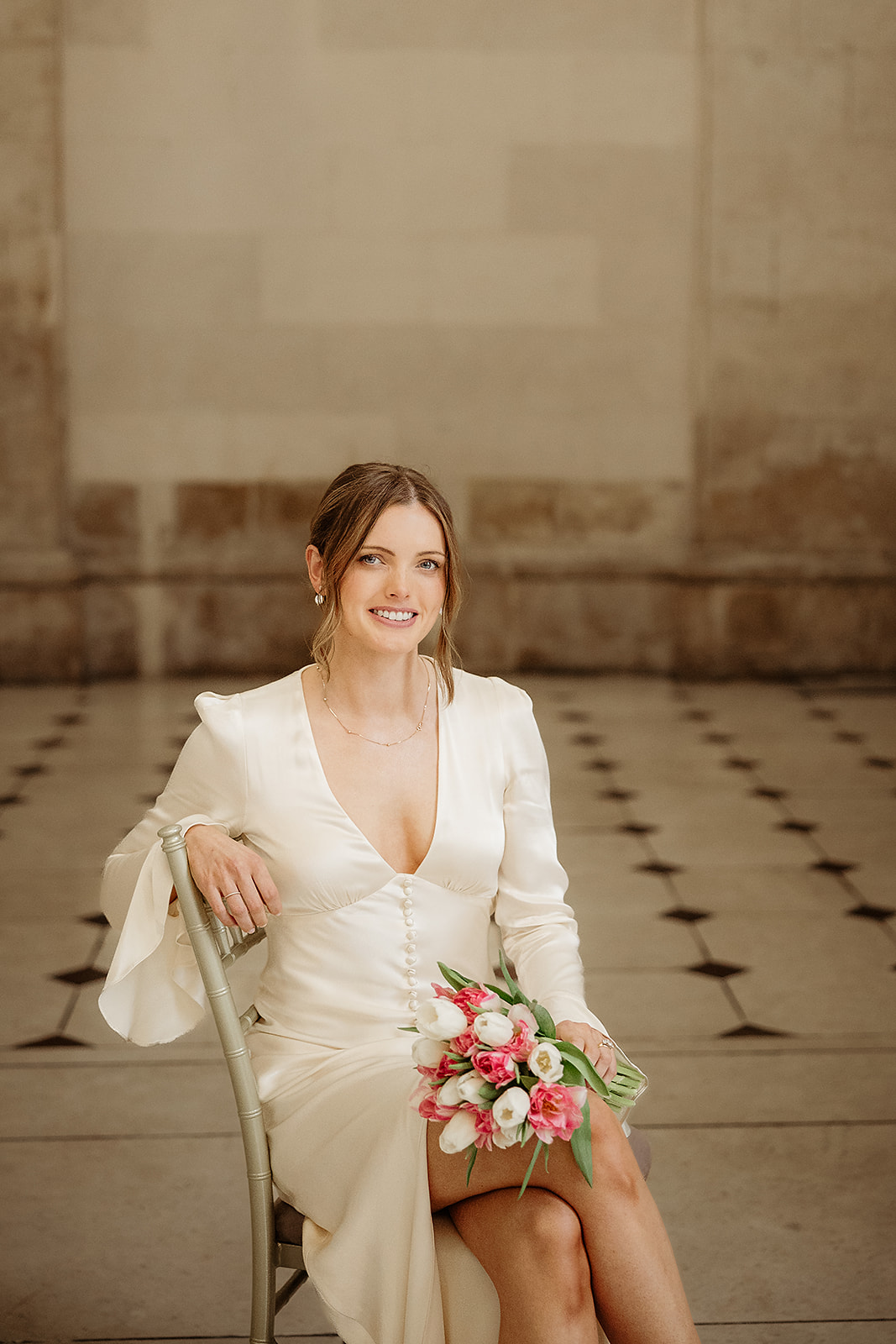 Hannah sitting with her bouquet inside Dublin City Hall