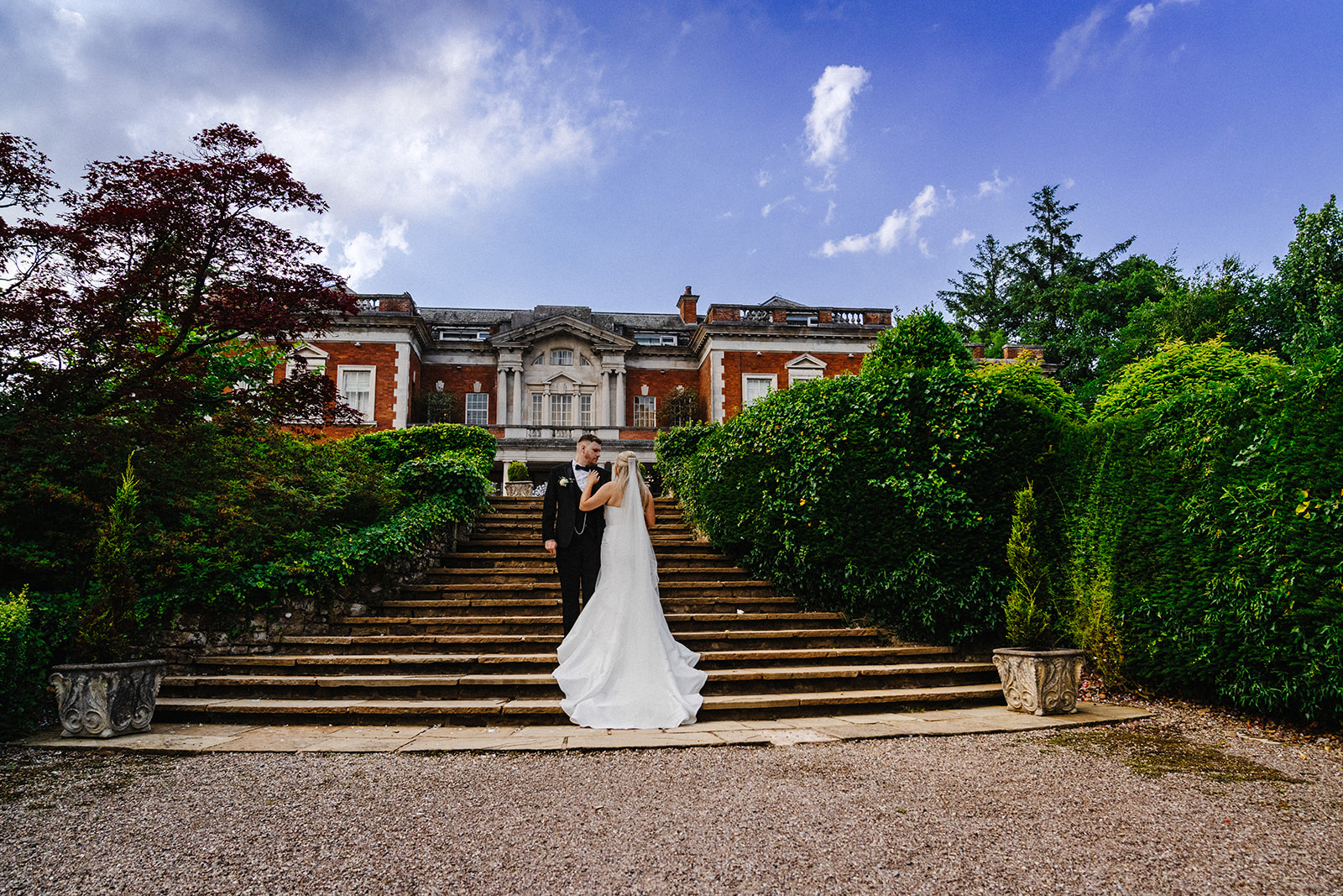 Emma and Brad on the garden steps in front of Eaves Hall