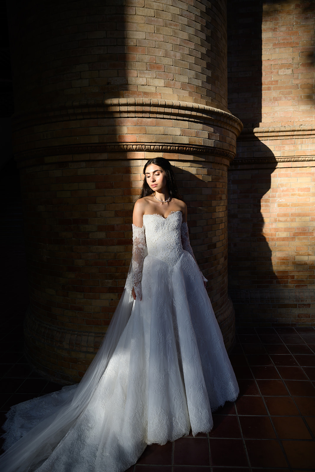 Bride standing in the brick arcades of Plaza de España in Seville