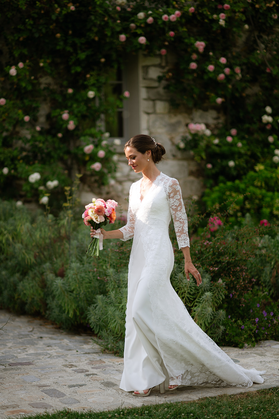 Bride walking through a rose garden at a château wedding in France