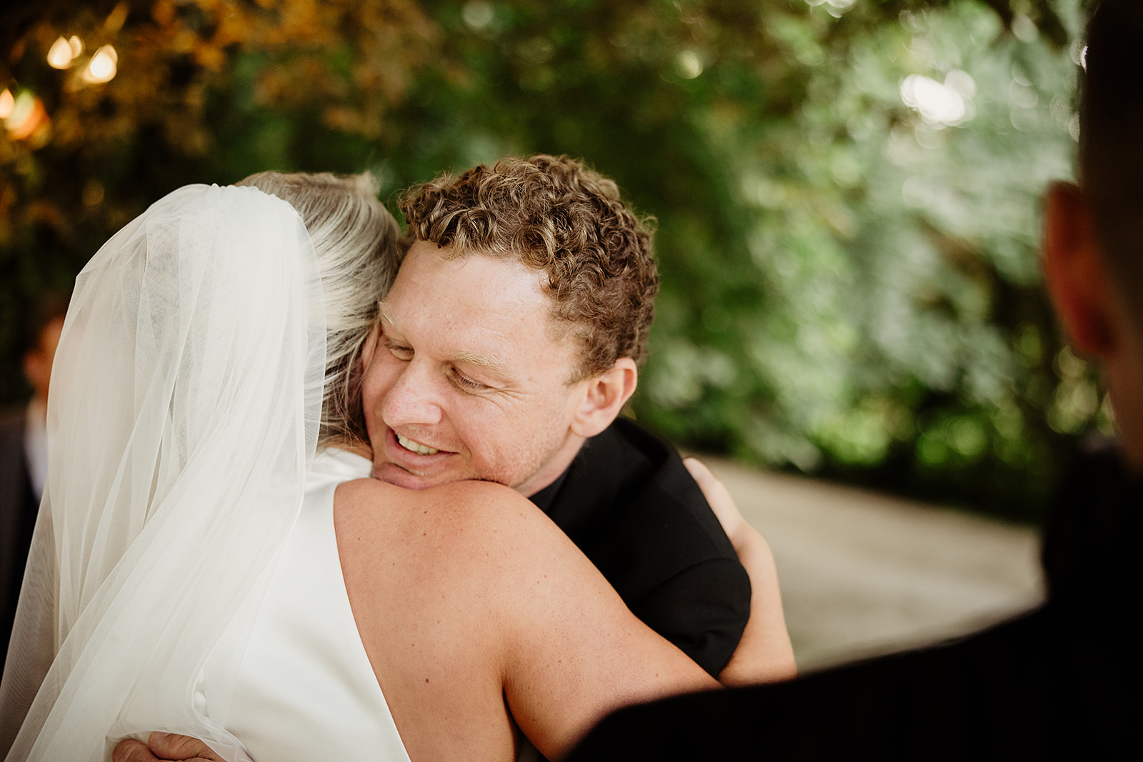 Julie embracing a guest after her outdoor wedding ceremony at the Station House Hotel