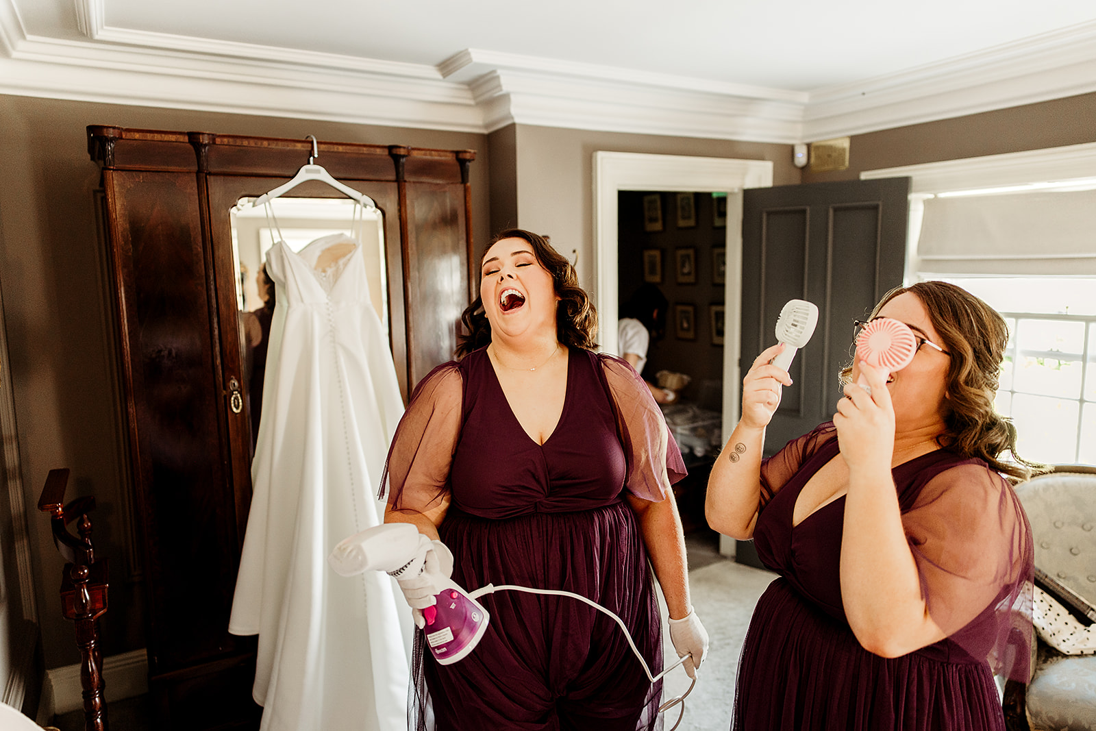 Bridesmaids laughing with handheld fans during the morning preparations