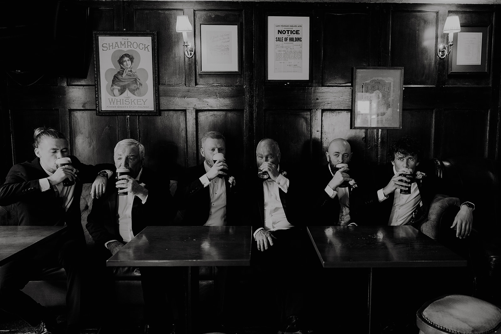 David and the wedding party sharing a drink at Clonabreany House, photographed in black and white.