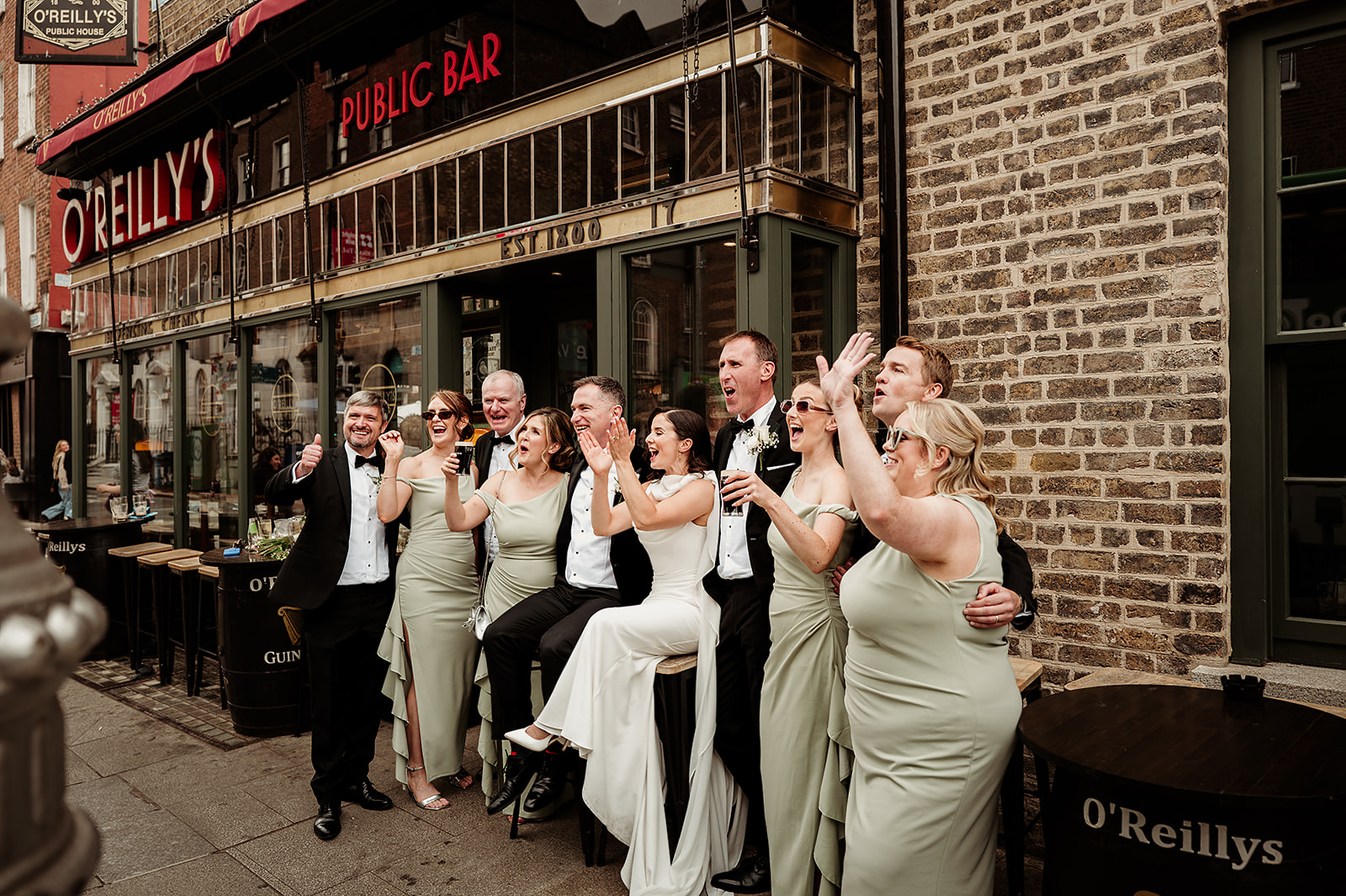Rebecca and Louis celebrating with their wedding party outside a Dublin pub